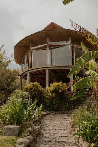 a house with glass windows on top of a hill at Saasil Retreat in Tzununá