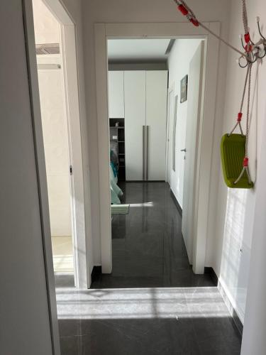 a hallway with white walls and a green purse at Appartamento Loreto-Fiera in Cremona