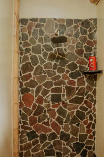 a bathroom with a stone wall with a shower at Saasil Retreat in Tzununá