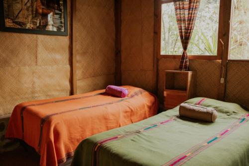 a room with two beds and a television in it at Saasil Retreat in Tzununá