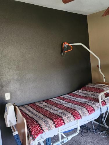a bed in a room with a lamp on the wall at Skyfire Ranch in Caldwell