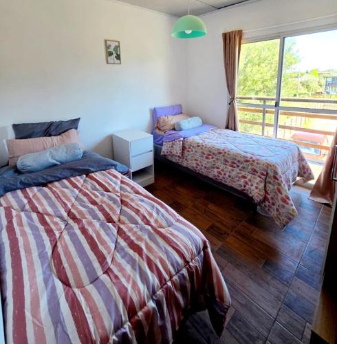 a bedroom with two beds and a window at MaryJor in La Pedrera