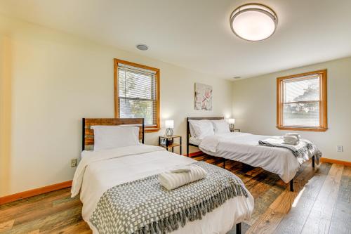 two beds in a room with two windows at 2 Mi to Walden Galleria Home with Furnished Deck! in Cheektowaga