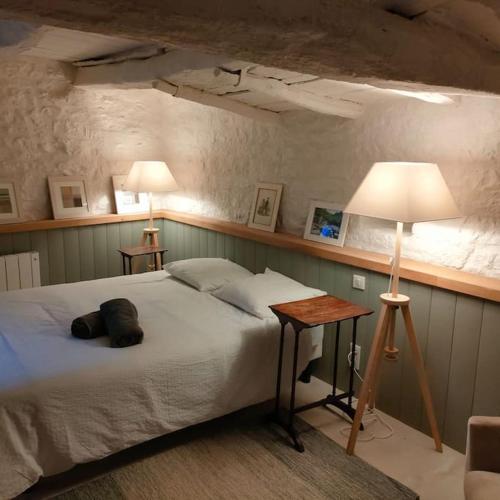 une chambre avec un lit et une table avec une lampe dans l'établissement 11 pers Les maisons médiévales de charme en Quercy, à Puylagarde