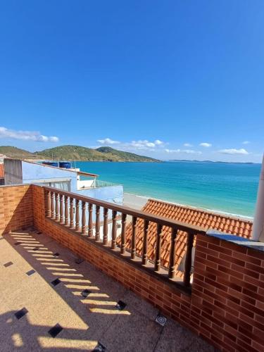 a balcony with a view of the beach at Estalagem pé na areia in Arraial do Cabo