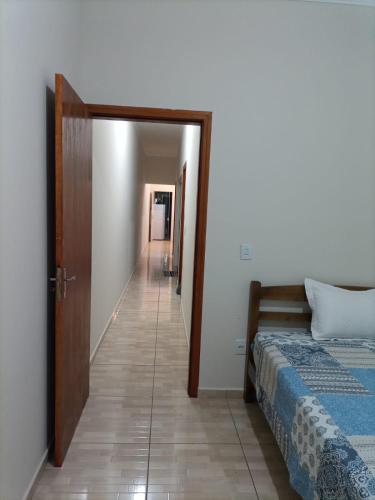 a hallway leading to a bedroom with a bed at Cozy Home 1 in Boituva