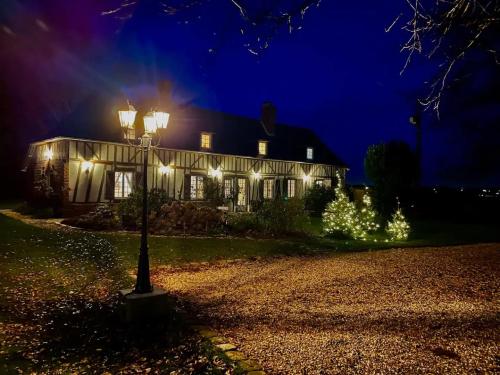 a house lit up at night with christmas lights at Cottage 4 chambres avec cheminée in Épégard