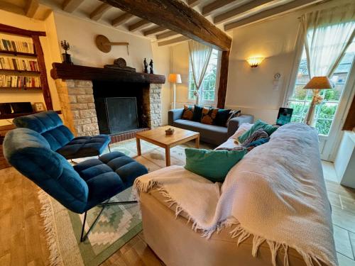 a living room with a couch and a fireplace at Cottage 4 chambres avec cheminée in Épégard
