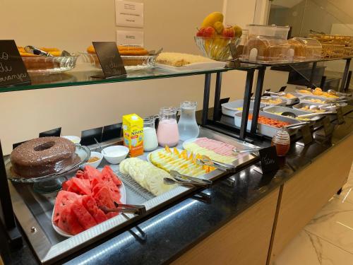 a buffet line with different types of food on display at HS Hotel in São Paulo
