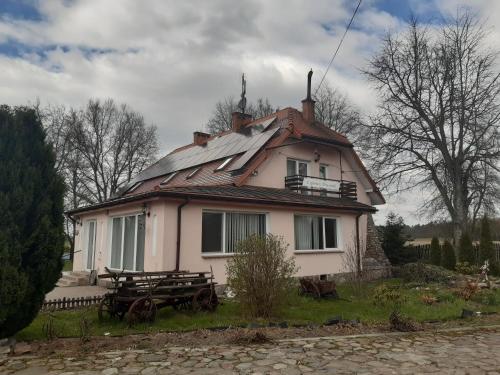 a large white house with a roof with solar panels at Pensjonat Lipowy Dworek in Staroguby