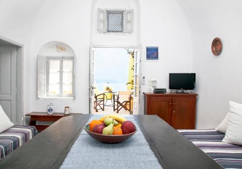 uma taça de fruta numa mesa numa sala de estar em Zoe Aegeas Traditional houses em Oia
