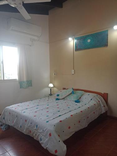 a bedroom with a bed with a comforter on it at Bungalows Jovi in Colón