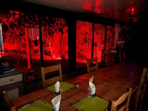 a dining room with a table and red lighting at Chambres et tables d'hôtes Zélia & Jacques BERQUEZ in Pianottoli-Caldarello