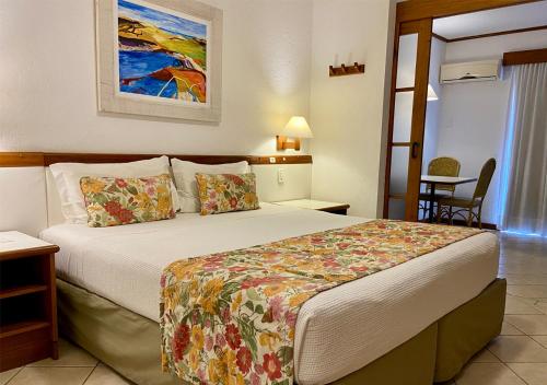 a hotel room with a bed and a table at Costa Norte Ingleses Hotel in Florianópolis