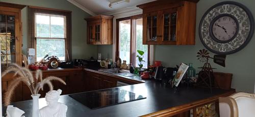 a kitchen with a large clock on the wall at Homestead BnB in Maudsland