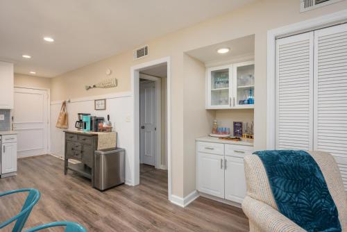 a kitchen with white cabinets and a table and chairs at The Islander- Luxurious Beach Property in Hilton Head Island