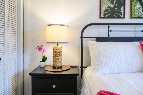 a lamp on a night stand next to a bed at The Islander- Luxurious Beach Property in Hilton Head Island