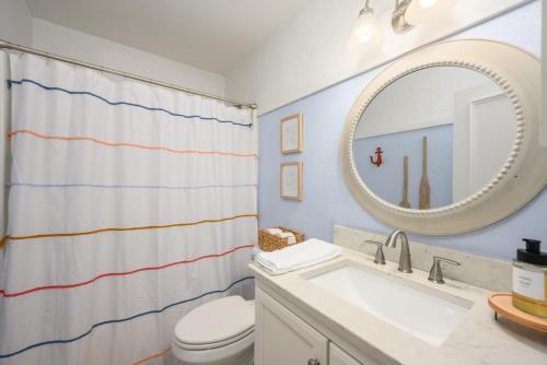 a bathroom with a sink and a toilet and a mirror at The Islander- Luxurious Beach Property in Hilton Head Island