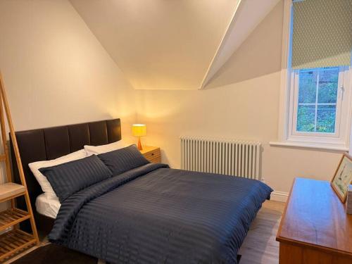 a bedroom with a bed and a desk and a window at April Cottage in Eastbourne