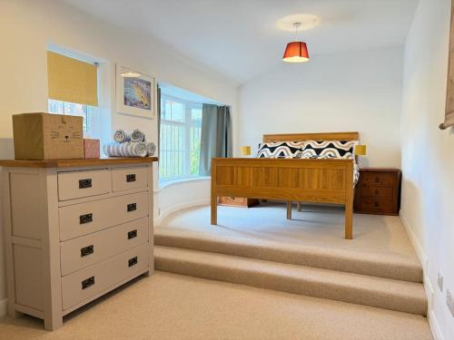 a bedroom with a bed and a dresser in a room at April Cottage in Eastbourne
