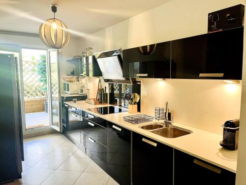 une cuisine avec un évier et un plan de travail dans l'établissement Résidence Aquarelle, appartement spacieux et chaleureux, grande terrasse, à Besançon