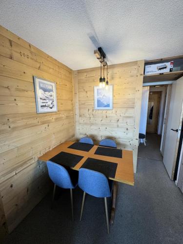 une salle à manger avec une table et des chaises bleues dans l'établissement Résidence Les Constellations - maeva Home - Studio 4 Personnes - Confort MAE-2024, à La Plagne Tarentaise
