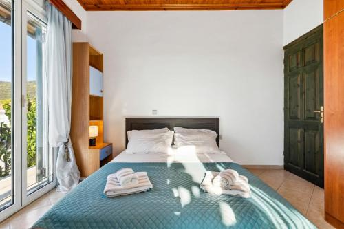 a bedroom with a bed with towels on it at Verani Residence Parking Balcony Playground in Sívros