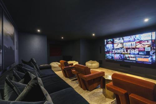 a living room with couches and a large screen television at Beaumont Exquisite Lakeland House, Sleeps 10 in Windermere