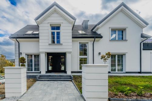 een wit huis met een oprit bij Willa Nad Parkiem in Krynica Zdrój