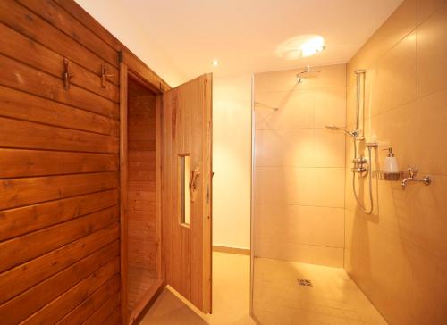 a bathroom with a shower with a glass door at Appartementhaus Gratz in Wagrain