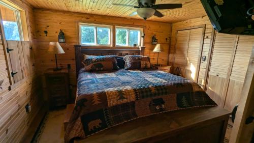 a bedroom with a bed in a wooden cabin at Cozy Cabin on 80 acres in The Ozarks, very unique! in West Plains