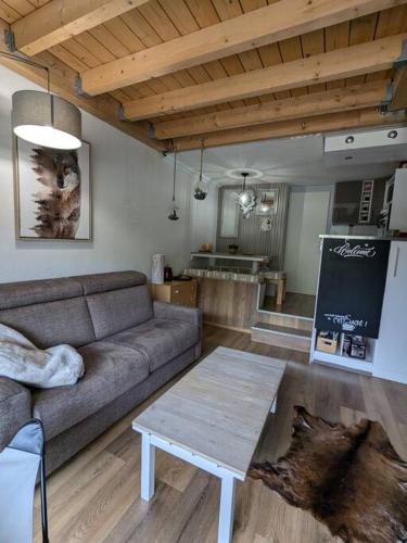 un salon avec un canapé et une table dans l'établissement La Foux d'Allos Duplex au pied des pistes, à La Foux d'Allos