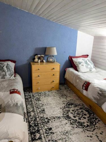 une chambre avec deux lits et une table avec une lampe dans l'établissement La Foux d'Allos Duplex au pied des pistes, à La Foux d'Allos