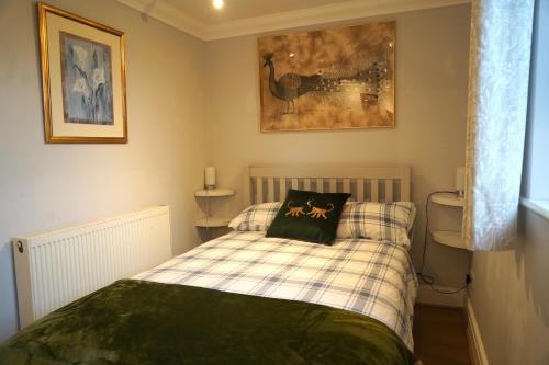 a small bedroom with a bed with a pillow on it at 3-bed cottage in Sway, New Forest (5 min walk from Sway Train Station) in Sway