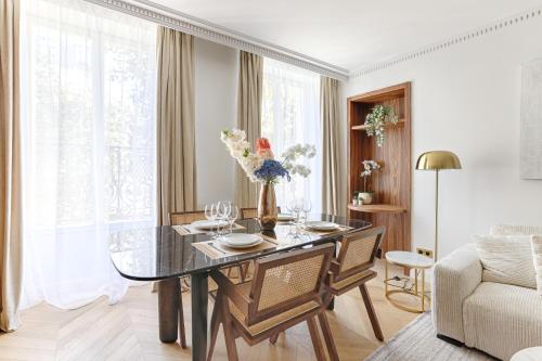 une salle à manger avec une table en verre et un canapé dans l'établissement Stunning 2 bedroom at Montparnasse, à Paris