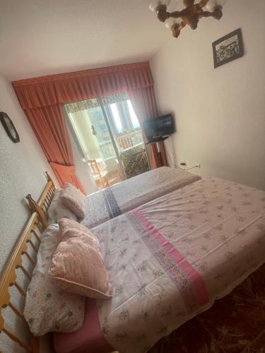een slaapkamer met een bed en een raam bij Benidorm Levante in Benidorm