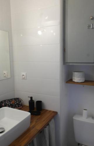 une salle de bain avec un lavabo blanc et un miroir dans l'établissement Studio cabine avec terrasse, vue sur le port, entre plage et port, avec parking, au Cap d'Agde