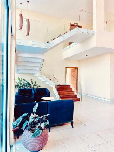 a living room with a blue couch and stairs at Mandai Apartamentos in Cabo Frio