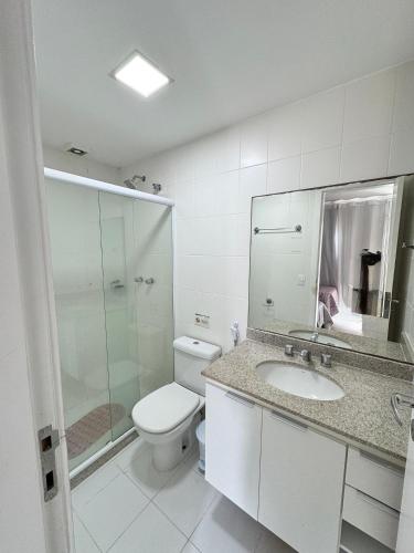 a bathroom with a toilet and a sink and a shower at Mandai Apartamentos in Cabo Frio