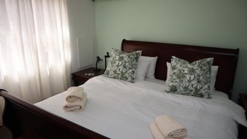 a bedroom with a bed with towels on it at Strand Beach Townhouse Self Catering in Cape Town