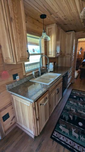 a kitchen with a sink and a counter in a cabin at Cozy Cabin on 80 acres in The Ozarks, very unique! in West Plains