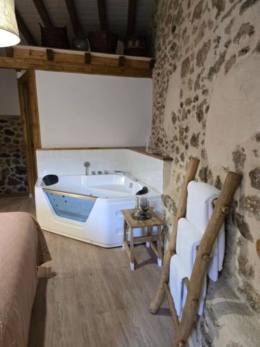 a bedroom with a bath tub in a stone wall at La casa del Mayoral in Tremedal