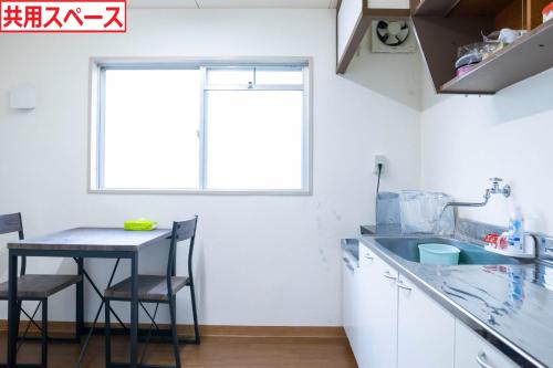 a kitchen with a sink and a table with chairs at Kumano Yadoumi Hikari Annex - Vacation STAY 91089v in Kumano