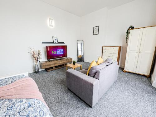 a living room with a couch and a tv at Central Southsea Guest House in Portsmouth