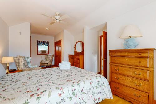 a bedroom with a bed and a dresser at Trotting Park Paradise in West Dennis