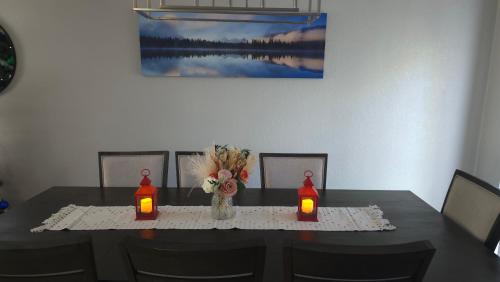 a dining table with two candles and a vase with flowers at Colorado Four Season Funhouse in Colorado Springs