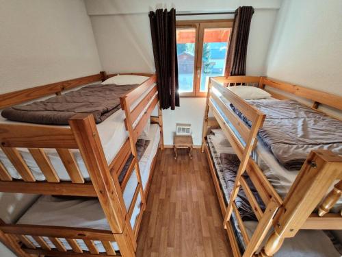 une chambre avec deux lits superposés et une fenêtre dans l'établissement Chalets De Florence - 4 pièces centre station 6/8 personnes MAE-2916, à Modane