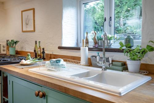 a kitchen counter with a sink and a window at The Old Mill in Paignton