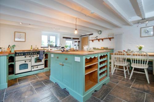 a kitchen with blue cabinets and a table and chairs at The Old Mill in Paignton