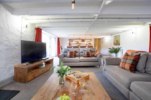 a living room with a couch and a tv at The Old Mill in Paignton